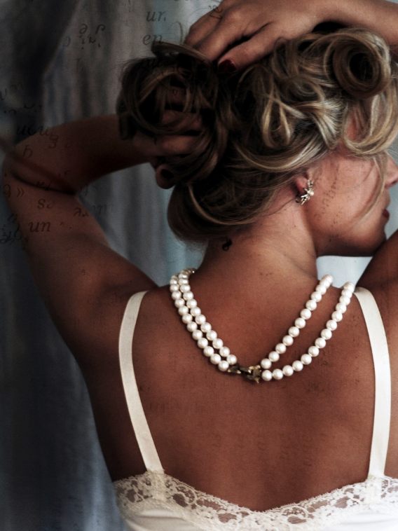 Mulher com um colar de pérolas ao pescoço