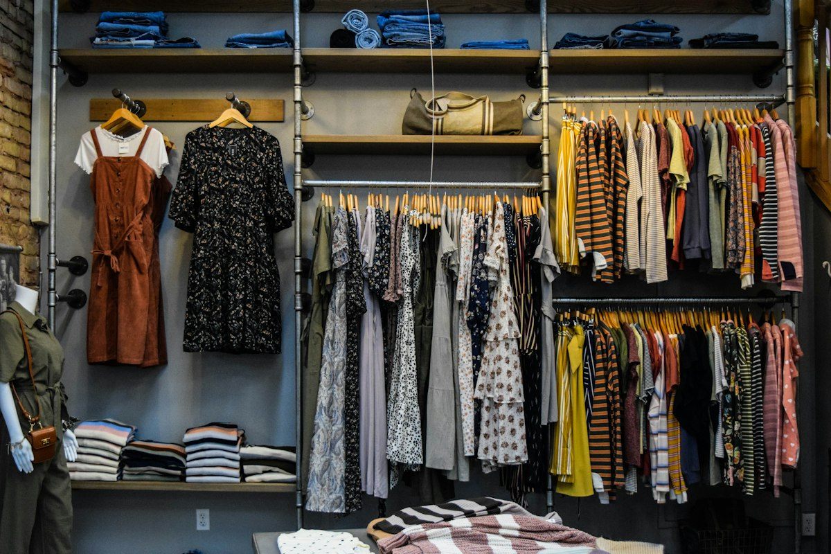 Interior de uma boutique com peças de roupa suspensas em araras